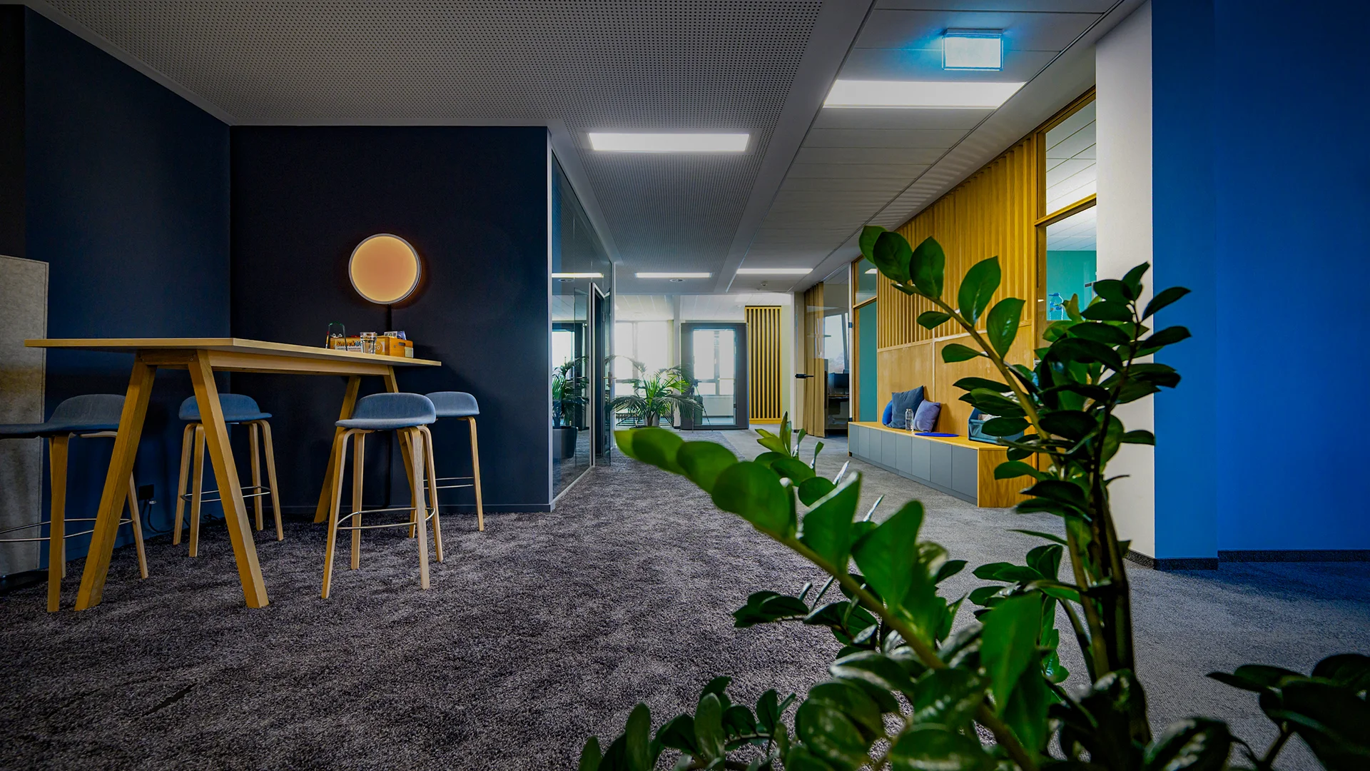 Moderner Bürobereich von ai Consult mit Sitznischen, Pflanzen und natürlichem Licht – zeigt eine offene Unternehmenskultur und nachhaltiges Arbeitsplatzdesign.